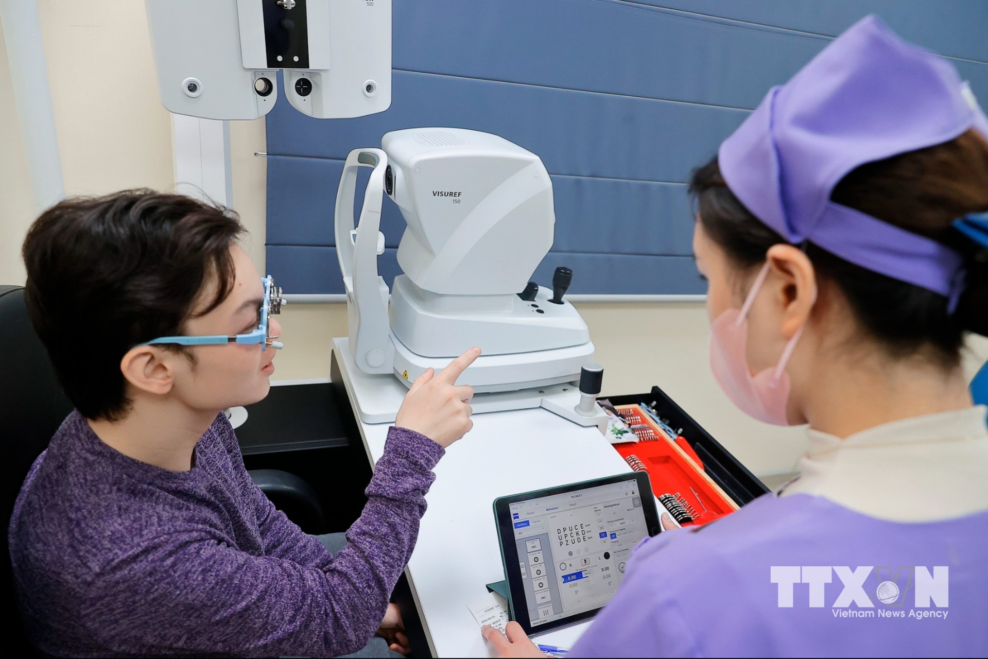 Kỹ thuật viên đo khúc xạ cho khách tại bệnh viện đa khoa Tâm Anh. (Ảnh Minh Quyết/TTXVN)